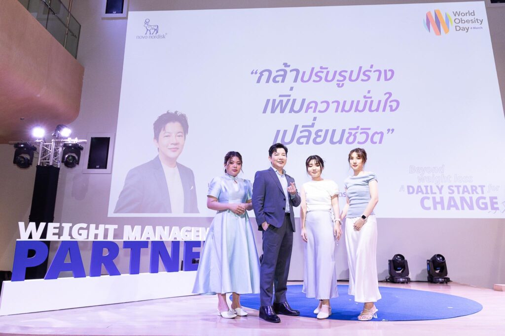 กลุ่มผู้บริหารและผู้ร่วมงานยืนอยู่บนเวที