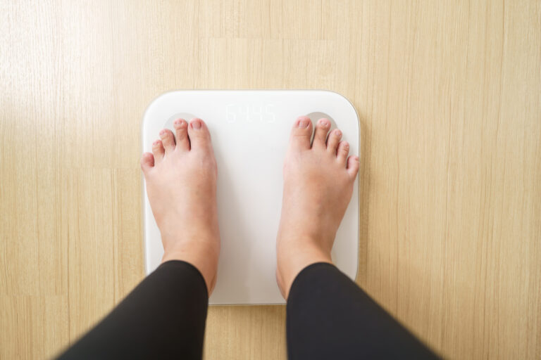 Woman standing on weigh electronic scalesfor check weight. diet