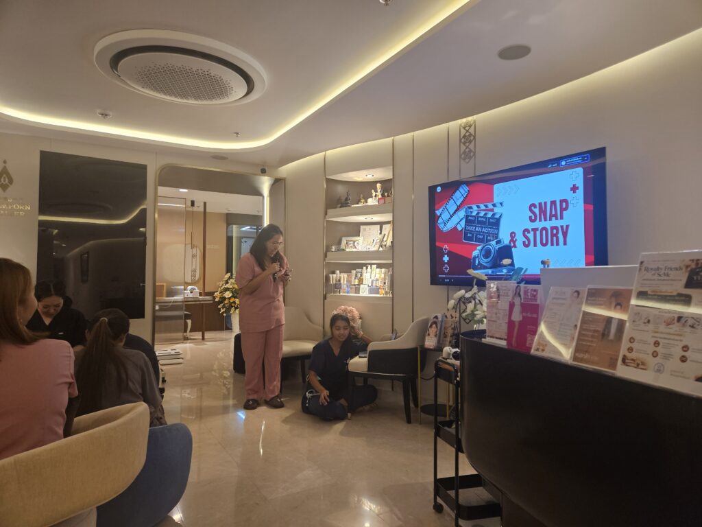 ทีมงานในชุดสีชมพูนำเสนอหัวข้อ Snap & Story ต่อผู้ร่วมประชุม